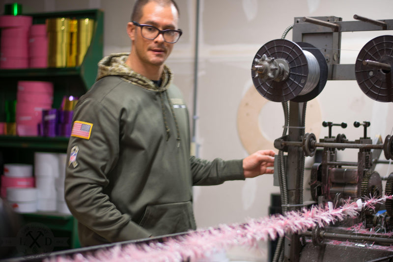 Lee Display's Brian Latino runs the Brush Machine to build a 25FT long strand of Pink Tinsel Garland using new improved methods
