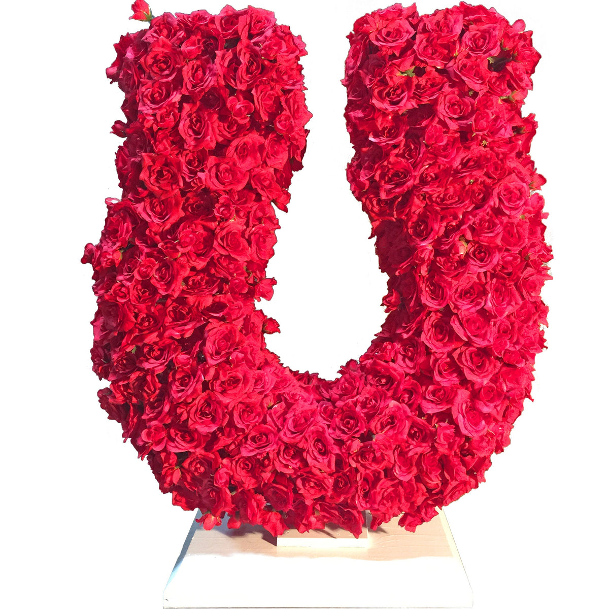 30in tall Rose Petal Horseshoe Centerpiece and Tabletop Display made with artificial rosebud flowers on a foam core and a wooden base painted in red.