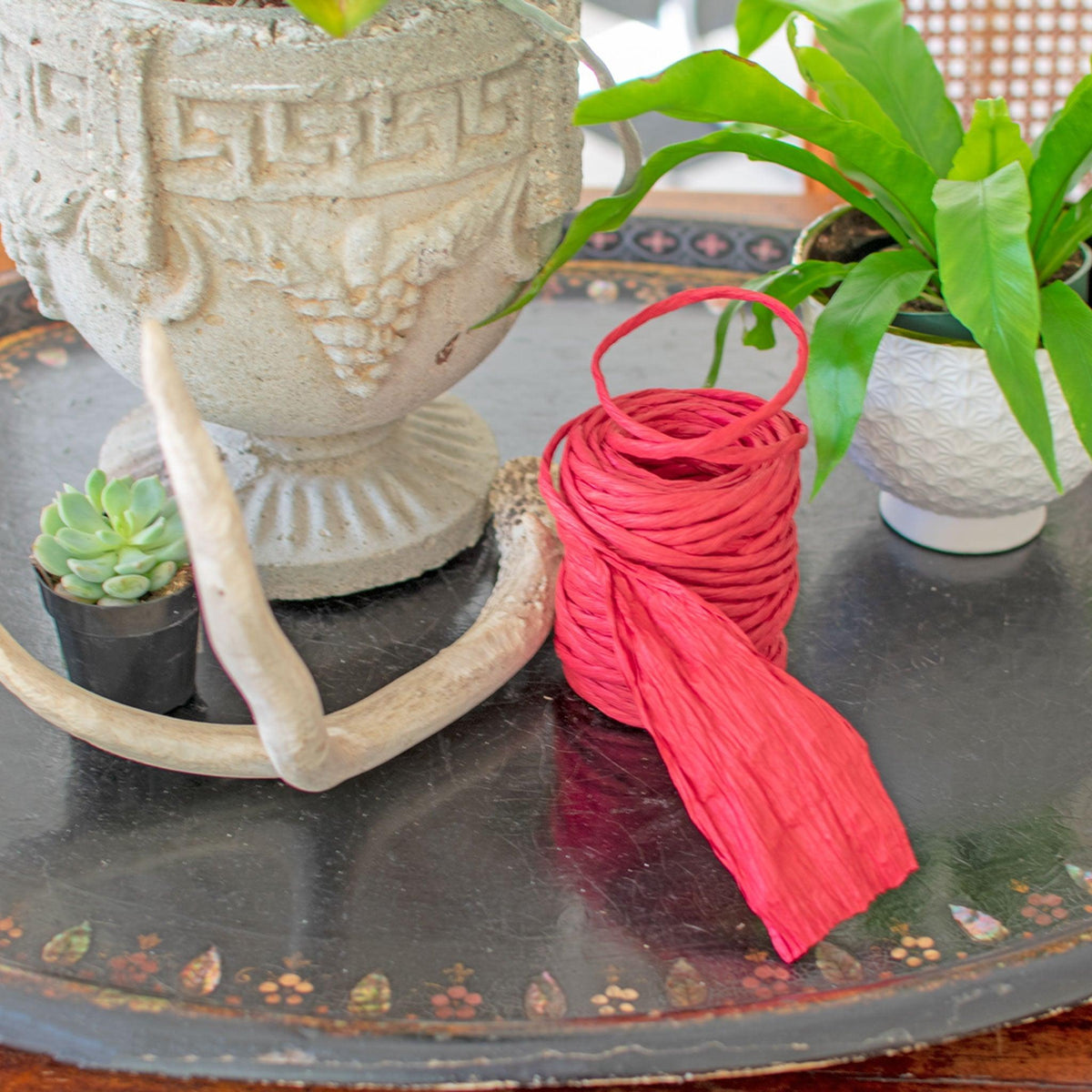 Lee Display's roll of Red Raffia Paper on a table